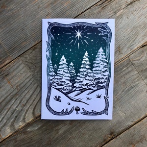 Puede incluir: Una ilustraci&oacute;n en blanco y negro de una escena de bosque nevado con una estrella en el cielo. Los &aacute;rboles son altos y delgados, y la nieve cae suavemente. Hay un peque&ntilde;o hongo en primer plano.