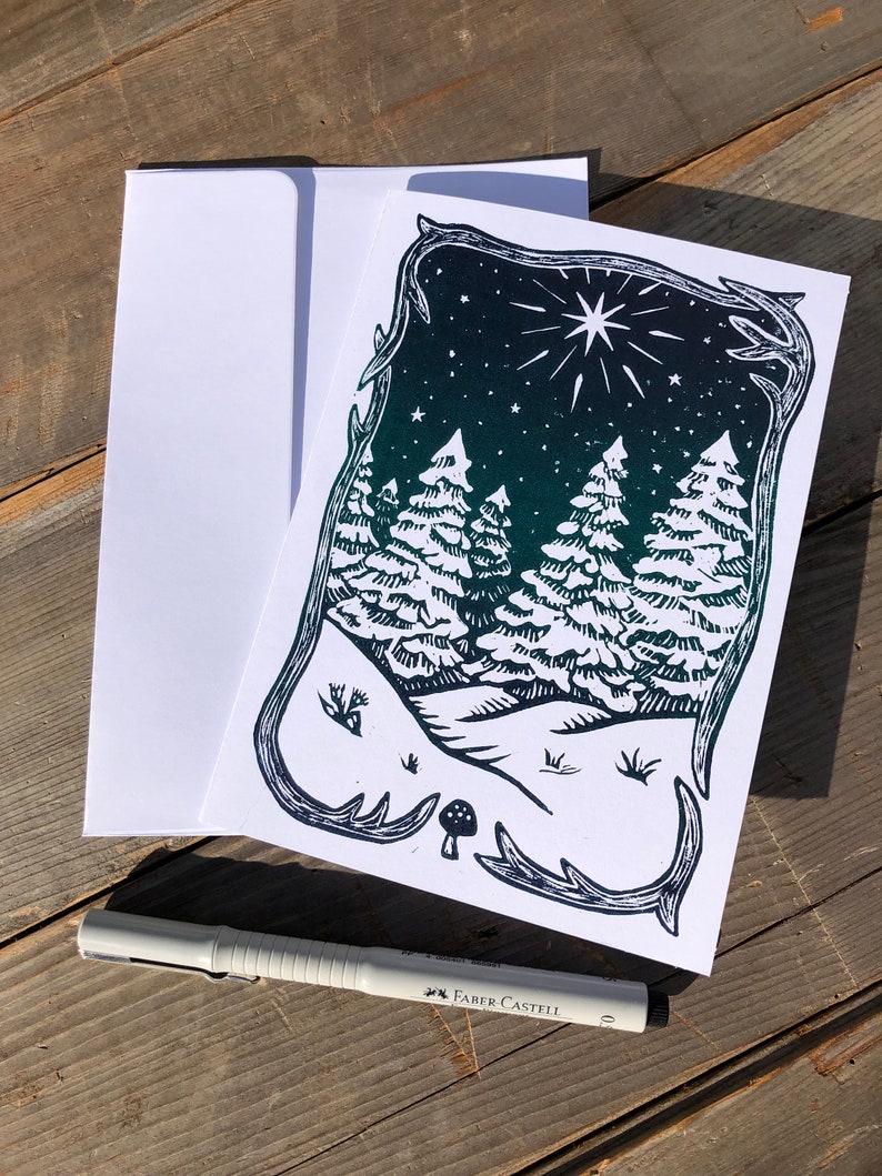 Puede incluir: Una ilustraci&oacute;n en blanco y negro de una escena de bosque con una estrella en el cielo nocturno. Los &aacute;rboles est&aacute;n estilizados y la escena est&aacute; enmarcada por un borde decorativo.