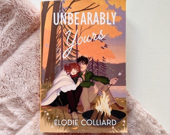 May include: Book cover with a couple sitting by a campfire in a forest. The title of the book is "Unbearably Yours" by Elodie Colliar.