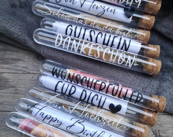 Könnte beinhalten: Ein Set aus klaren Glasröhrchen mit Korkstopfen, jedes mit einem eingerollten Papierstück mit handgeschriebenen Botschaften. Die Botschaften lauten: "Happy Birthday", "Von Herzen", "Schon das du da bist", "Gutschein", "Dankeschön", "Wunscherfüller für dich", "Zur Hochzeit" und "Happy Birthday".