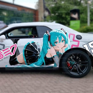 Könnte beinhalten: Weißes Sportwagen mit schwarzen Rädern und rosa Akzenten, mit einer großen Anime-Illustration eines weiblichen Charakters mit türkisfarbenem Haar. Japanischer Text und grafische Elemente sind ebenfalls sichtbar.