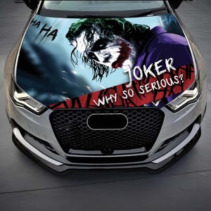 以下が含まれることがあります： 「JOKER WHY SO SERIOUS？」のテキストが入ったジョーカーのグラフィックが特徴の車のボンネットラップ。デザインにはジョーカーの顔、「HA HA」の文字、赤と青の背景が含まれています。