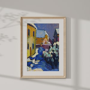 May include: A painting depicting a snowy village street with colourful houses and a blue sky. The houses are painted in shades of yellow, orange, and red. The street is covered in snow and the sky is a light blue. The painting is framed in a wooden frame.
