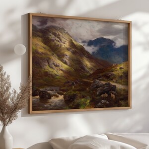 Puede incluir: Una pintura de paisaje enmarcada que representa un valle montañoso con un arroyo que lo atraviesa. El cielo está nublado y las montañas son verdes y marrones. Hay ovejas pastando en el valle.