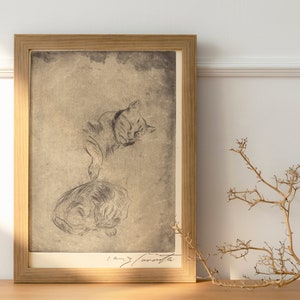 May include: A framed black and white drawing of two cats sleeping. The drawing is on a beige background and is framed in a light brown wood frame.