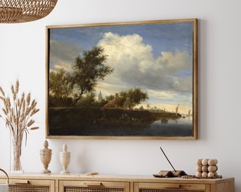 May include: A framed landscape painting depicting a river scene with a cloudy sky, green trees, and a small village in the distance. The painting is set in a wooden frame and is hanging on a white wall.