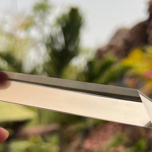 May include: A clear glass prism with a rectangular shape, reflecting light.