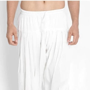 Könnte beinhalten: Weiße Baumwollhose mit gerafftem Bund und lockerer, fließender Passform.