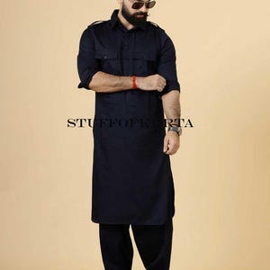Peut inclure: Un ensemble kurta pajama bleu marine. La chemise à manches longues a deux poches de poitrine et des épaulettes. Le pantalon assorti est ample. Le texte "STUFFOFKURTA" est imprimé au bas de l'image.