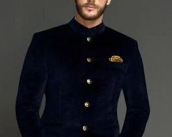 May include: A navy blue velvet blazer with a mandarin collar and gold buttons. The blazer has a pocket on the left side with a gold embroidered design.