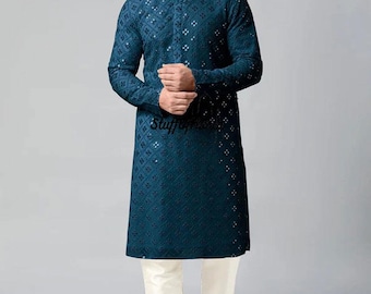 May include: A teal blue long-sleeved kurta with a white geometric pattern. The kurta has a mandarin collar and a button closure. The model is wearing white pants and white shoes.