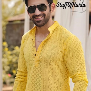 May include: A man wearing a yellow embroidered kurta with a button-up collar and long sleeves. He is wearing sunglasses and smiling. The text "Stuff of Kurta" is visible in the top right corner of the image.