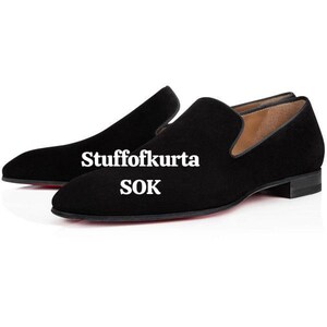 Pu&ograve; includere: Scarpe slip-on in camoscio nero con tacco basso e suole rosse. Le scarpe hanno la punta arrotondata e un design classico. Il testo "Stuffofkurta SOK" &egrave; stampato sul lato.