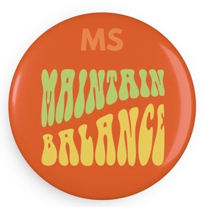 May include: Orange round button with the text "MS" in the top center and the text "MAINTAIN BALANCE" in a retro, wavy font in green and yellow.