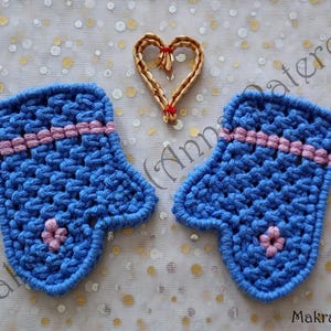 Może przedstawiać: Dwa niebieskie rękawice szydełkowe z różowymi paskami i małym różowym kwiatkiem. Nad rękawicami znajduje się tkane serce. Tło to biała tkanina ze złotymi i białymi kropkami. Tekst "Makrania.pl" znajduje się w prawym dolnym rogu.