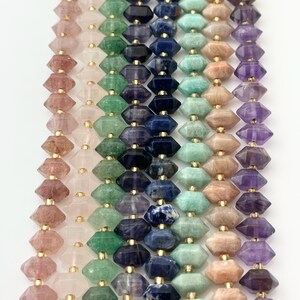 May include: A strand of faceted gemstone beads in various colors, including pink, green, blue, and purple. The beads are strung on gold wire.