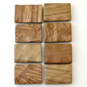 May include: Eight rectangular pieces of polished brown jasper stone arranged in two vertical columns. Each piece features unique natural wood-like grain patterns in shades of tan, beige, and dark brown with a smooth, slightly wavy surface texture.
