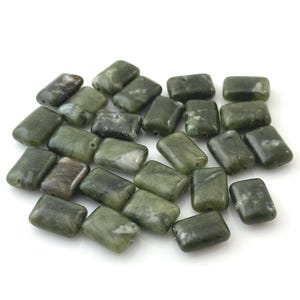 May include: A collection of rectangular beads in various shades of dark green, olive, and forest green. Each bead features a smooth, polished surface with natural white and dark grey marbling patterns throughout the stone-like material.