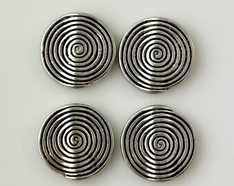 May include: Four silver-colored, circular metal components with a spiral design. Each component features a raised, concentric spiral pattern, creating a textured surface. The components are arranged in a square formation against a white background.
