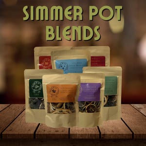 Peut inclure: Plusieurs mélanges pour pot-pourri dans des sachets transparents avec des étiquettes colorées. Les étiquettes indiquent des textes tels que "Holiday Spice Medley", "Sun Kissed Citrus Spice" et "Lavender Citrus Escape". Le texte "Simmer Pot Blends" est en haut.