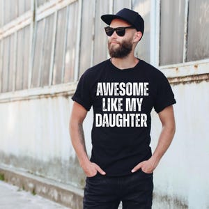 May include: A black t-shirt with white text that reads "Awesome Like My Daughter".