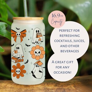 Op de afbeelding: Een frosted glazen beker met een bamboe deksel en rietje, met Halloween-thema illustraties. Het ontwerp bevat geesten, bloemen met schedelcentra, vleermuizen en strikken in oranje en zwart. Inhoud: ongeveer 500 ml.