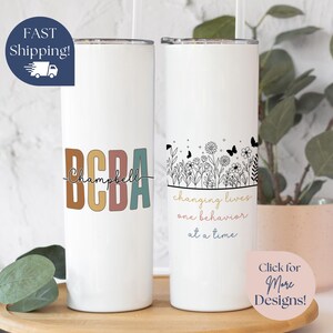 May include: Two white stainless steel tumblers with different designs. The first tumbler has the text "BCBA Campbell" in colorful letters. The second tumbler has a floral design with butterflies and the text "changing lives one behavior at a time".