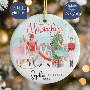 May include: Round Christmas ornament with a light blue background and a Nutcracker theme. The ornament features illustrations of characters from the ballet, including a ballerina, a nutcracker soldier, and a Christmas tree. Text includes "Nutcracker", "Sophia as Clara", and the year 2025.