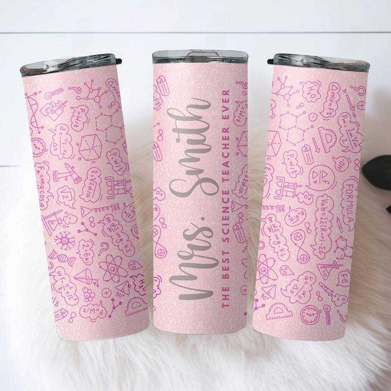 May include: Pink insulated tumbler with a black lid. The tumbler features a pattern of science-related doodles and the text "Mrs. Smith, The Best Science Teacher Ever" in grey lettering. The tumbler is designed to keep drinks hot or cold.