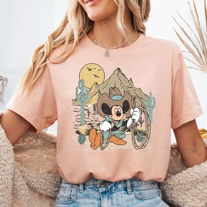 a woman wearing a pink shirt with a cartoon character on it