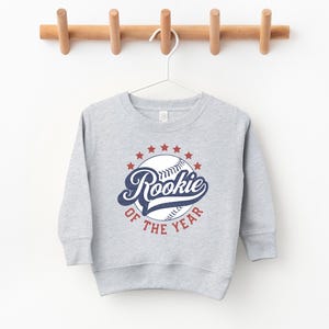 a baseball sweatshirt hanging on a wooden hanger
