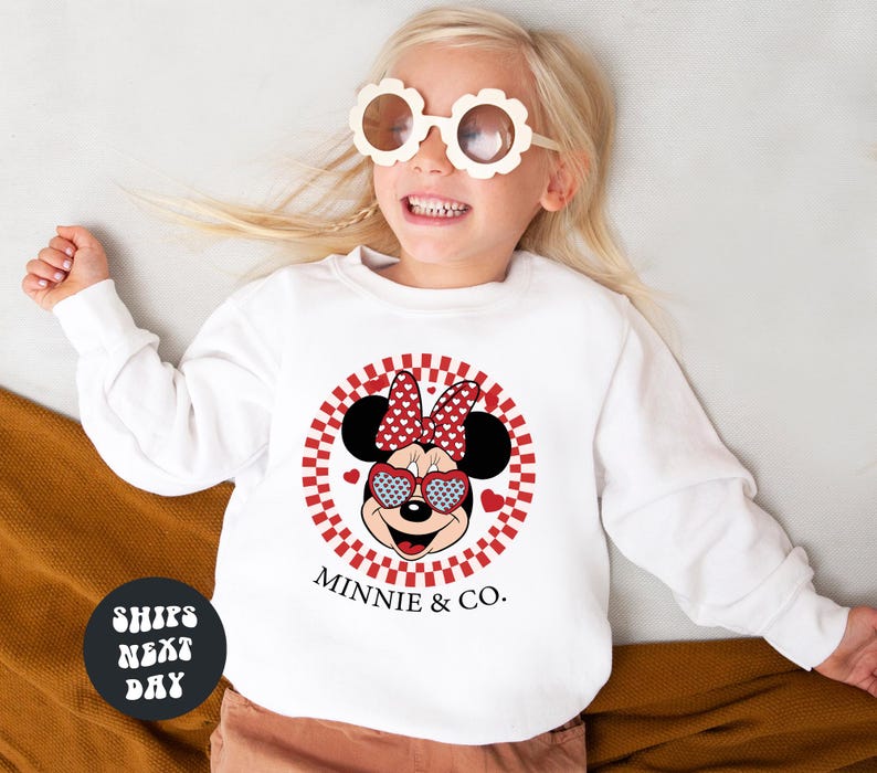 a little girl wearing a minnie mouse shirt