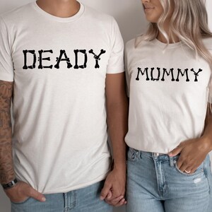 A man and a woman wearing matching t-shirts with the word "DEADY" and "MUMMY" printed on them.