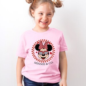 a little girl wearing a minnie mouse shirt