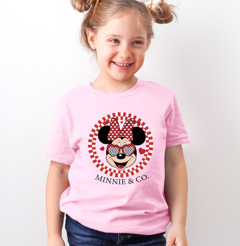 a little girl wearing a minnie mouse shirt