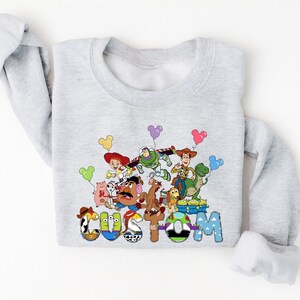 A gray long-sleeved shirt with a colorful graphic design featuring characters from the Toy Story movie.