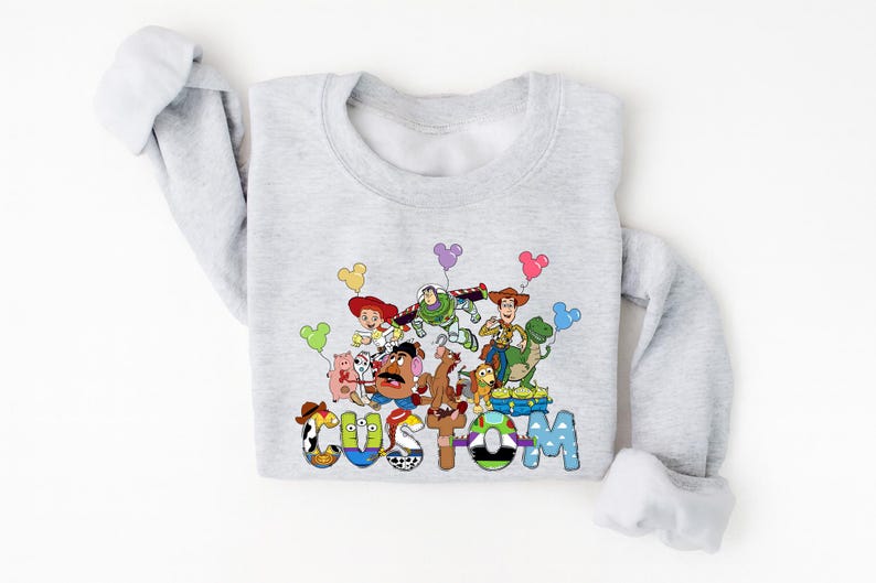 A gray long-sleeved shirt with a colorful graphic design featuring characters from the Toy Story movie.