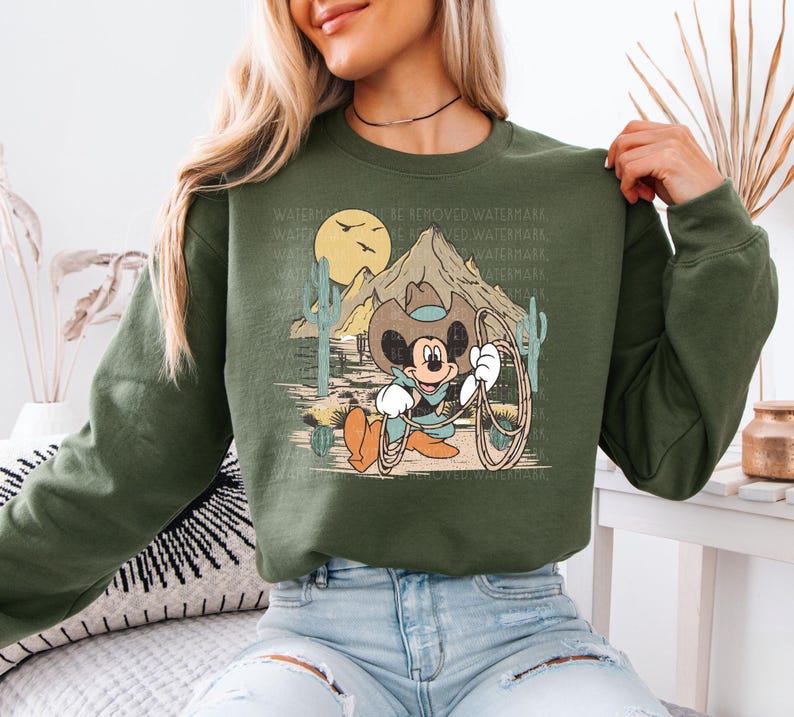 a woman wearing a green sweatshirt with mickey mouse on it