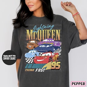 a woman wearing a gray tee shirt with cars on it