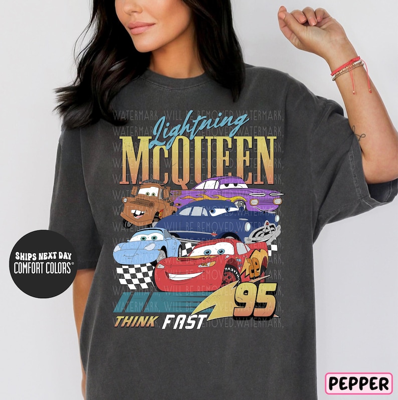 a woman wearing a gray tee shirt with cars on it