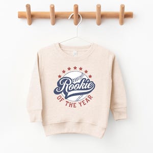 a baseball sweatshirt hanging on a wooden hanger