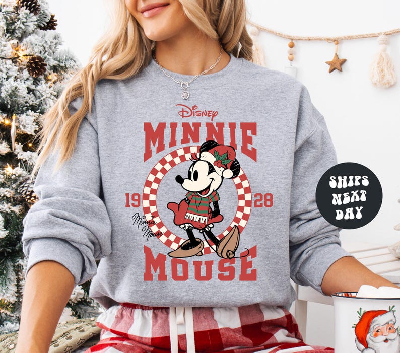 A woman wearing a gray sweatshirt with a graphic of Minnie Mouse and the text "Disney MINNIE MOUSE" printed on it.