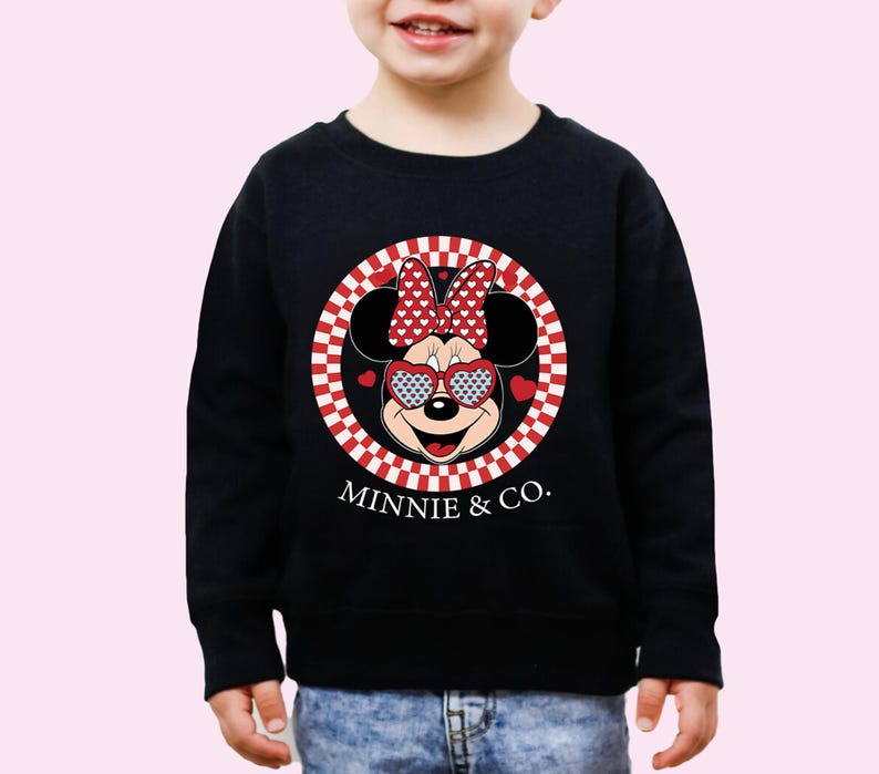 a young boy wearing a minnie mouse sweatshirt