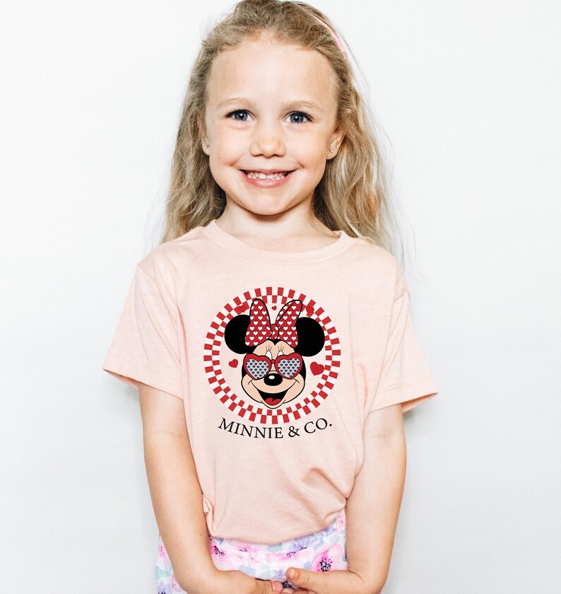 a little girl wearing a minnie mouse shirt