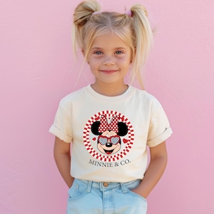 a little girl standing in front of a pink wall