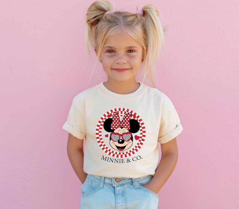 a little girl standing in front of a pink wall