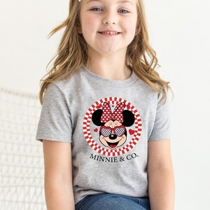 a little girl wearing a minnie mouse shirt