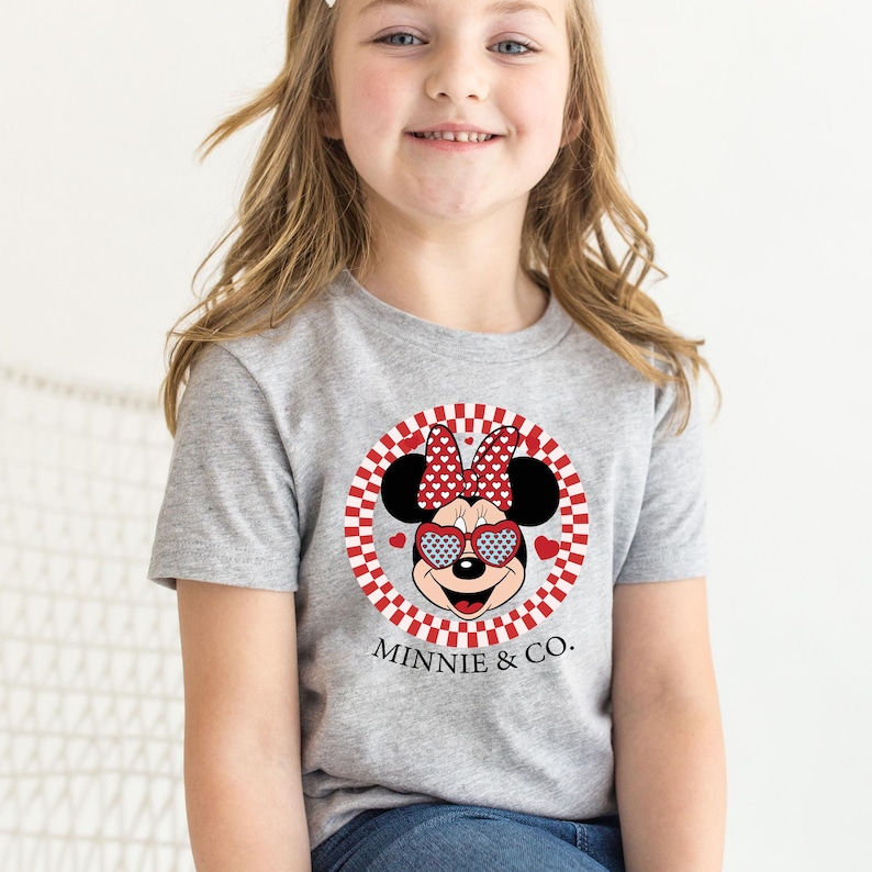 a little girl wearing a minnie mouse shirt