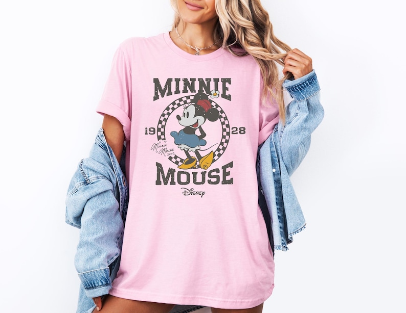 a woman wearing a pink minnie mouse t - shirt