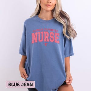 a woman wearing a blue t - shirt with the words nurse on it